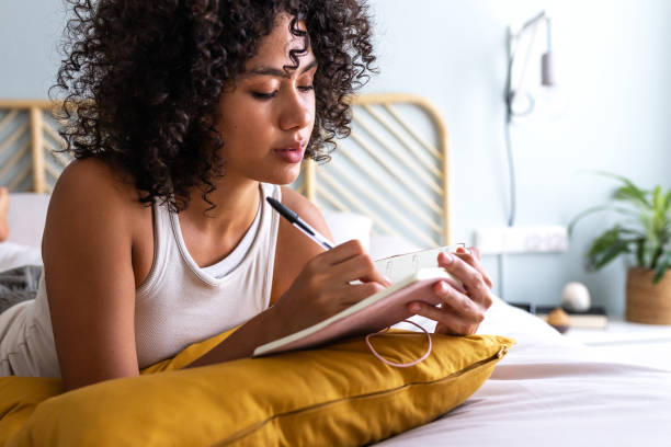 Woman journaling in a quiet moment of self reflection to support emotional balance and gentle self care