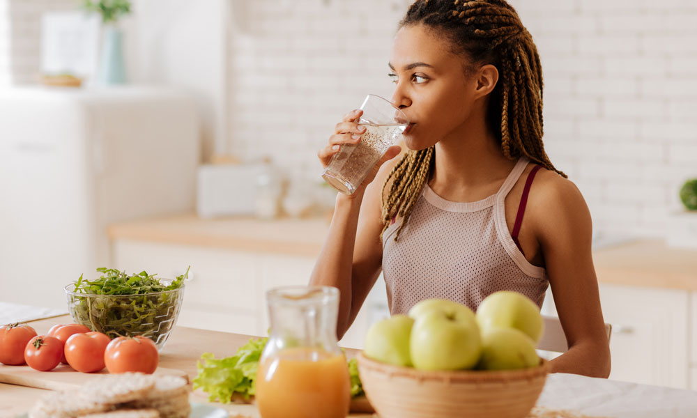 Woman drinking water to naturally boost energy and support daily wellness